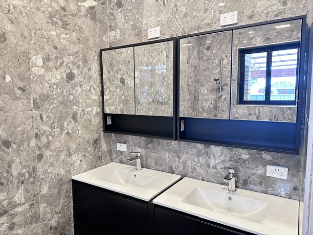 Finished bathroom with double vanity and stone-look tiles